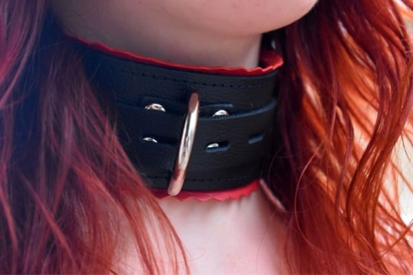 Redhead wearing a leather collar with red edges