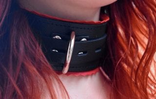 Redhead wearing a leather collar with red edges