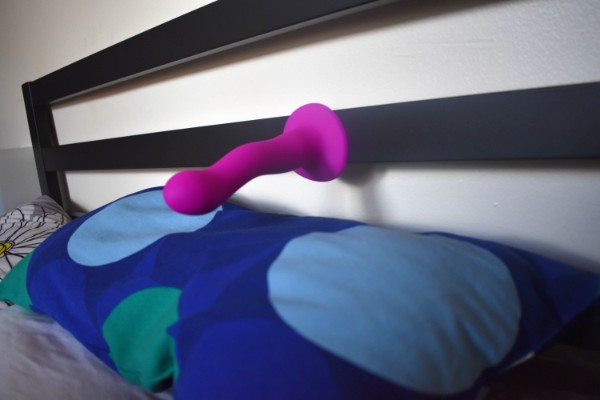 Suction cup dildo on a bed head board