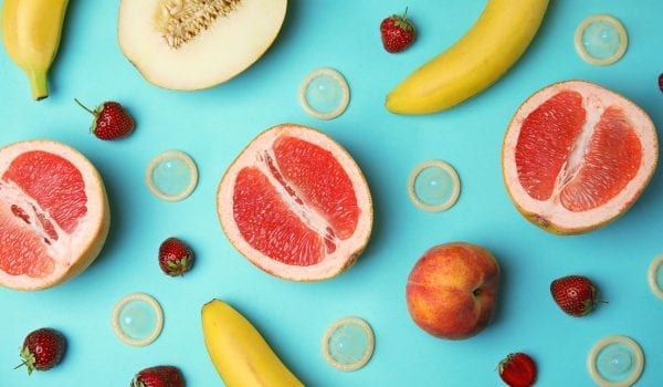 Flat lay composition with condoms and exotic fruits