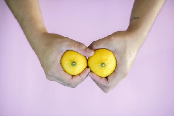 Man squeezing two lemons - breast play concept