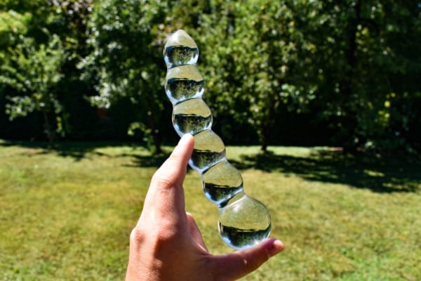 Male hand holding glass dildo