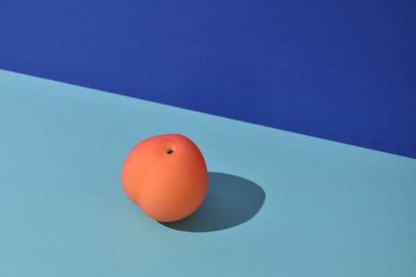 Womanizer Peach suction mouth on a artistic background