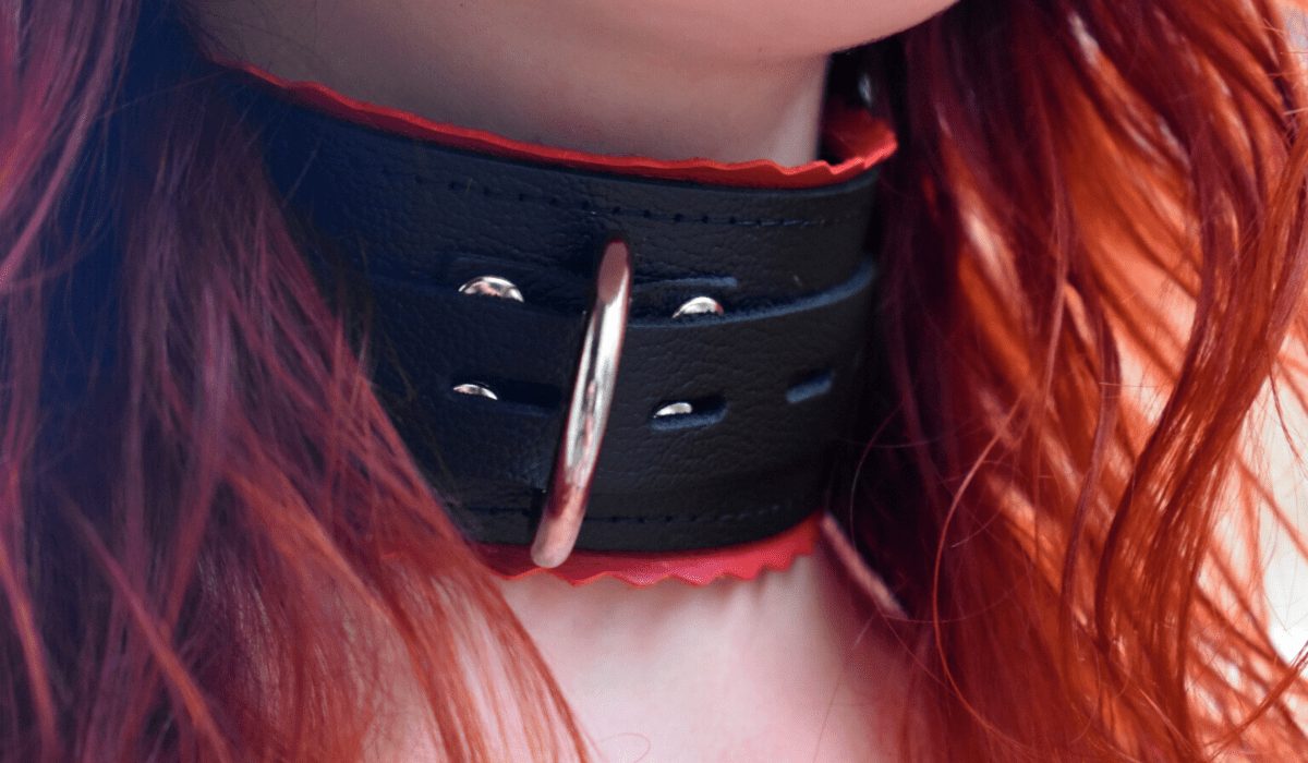 Redhead wearing a leather collar with red edges