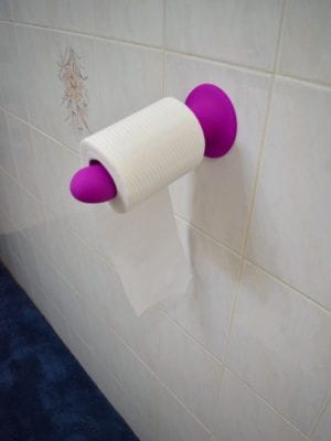 Suction cup dildo holding toilet paper