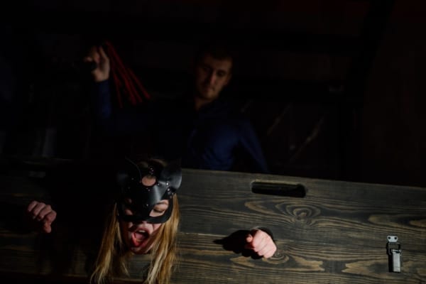 Girl restrained in a BDSM pillory flogged