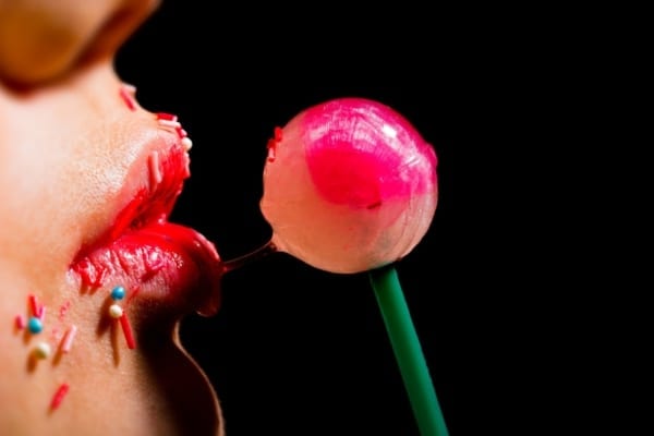 Woman licking a lollipop - oral sex concept
