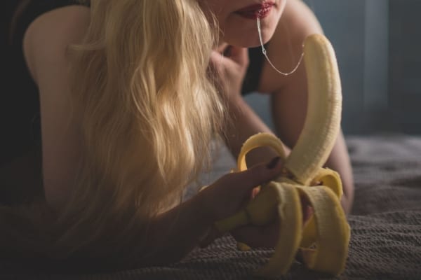 Woman practicing oral sex on a banana