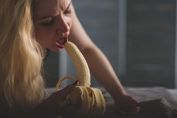 Woman sucking a banana