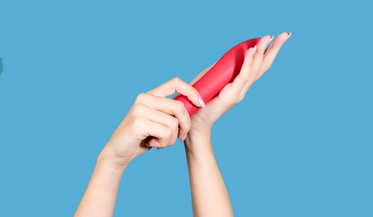 Two hands cleaning a sex toy